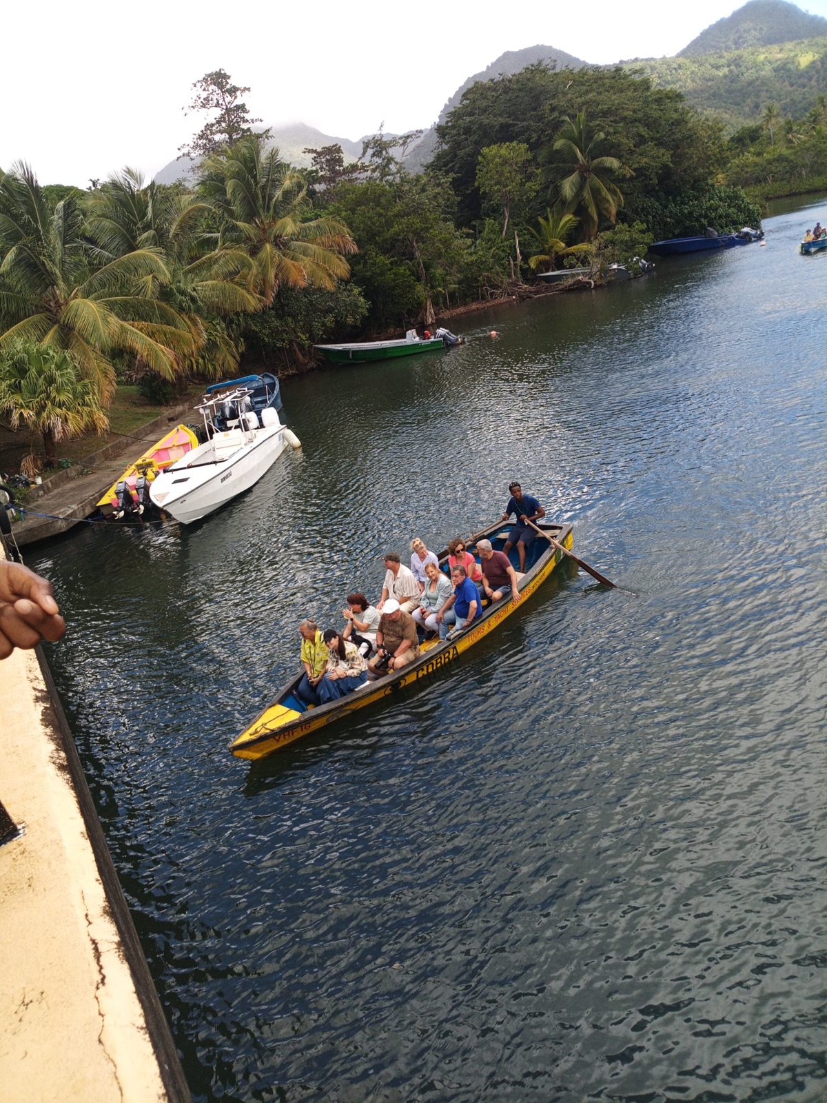 The wooden boat arriving at the dock with passengers aboard